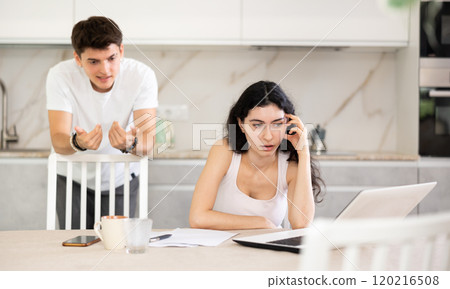 Young guy quarrels with young woman working at laptop Young guy quarrels with young woman working at laptop 120216508