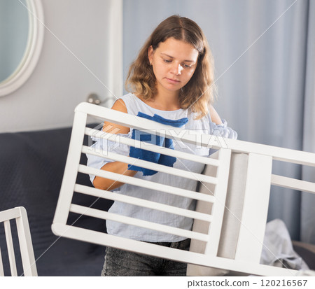 Young woman cleaning chair in living room Young woman cleaning chair in living room 120216567