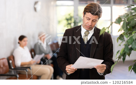 Adult man posing with documents in office Adult man posing with documents in office 120216584