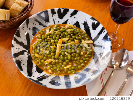 Green peas stewed with pieces of squid in appetizing gravy Green peas stewed with pieces of squid in appetizing gravy 120216839