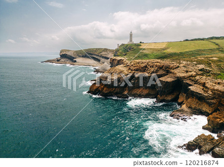Majestic cliffside view of a historic lighthouse on a rugged coastline 120216874