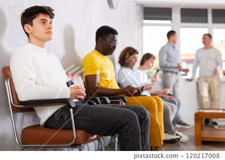 Young guy sitting at hall of civil service building 120217008