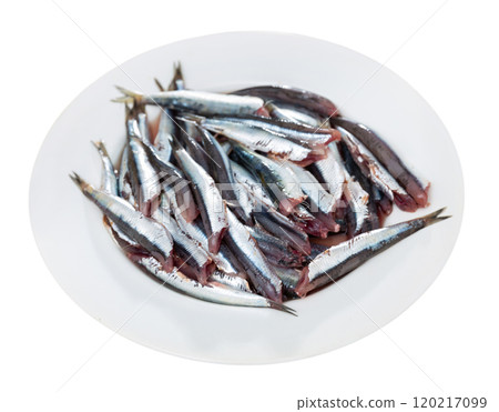 Pile of small raw fish is piled on plate, ready for frying 120217099