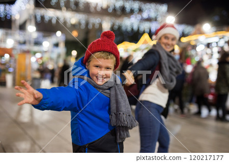 Tween boy pulling mothers hand at festive Christmas fair Tween boy pulling mothers hand at festive Christmas fair 120217177