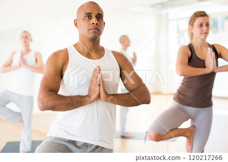 Latin american man standing in balancing pose Eka Pada Pranamasana 120217266