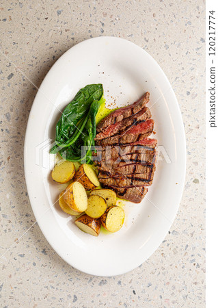 Portion of grilled top blade steak with potatoes Portion of grilled top blade steak with potatoes 120217774