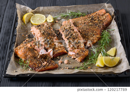 baked salmon fillet on baking tray, top view 120217789