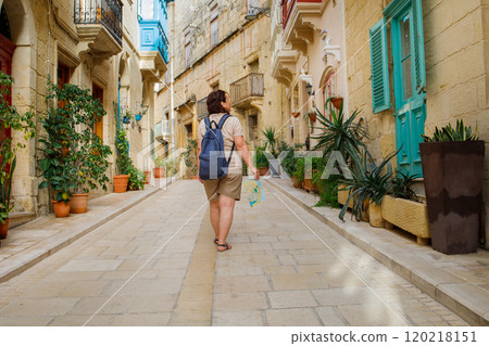 Woman tourist walking around Malta island with a paper map and backpack 120218151