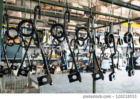 Industrial metal parts hanging in a factory 120218553