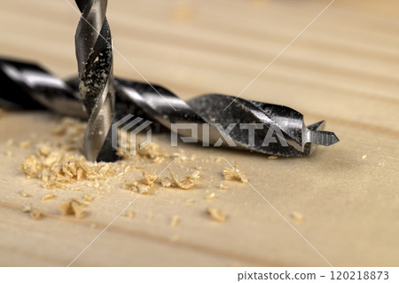 metal drill bit and pine wood board during operation metal drill bit and pine wood board during operation 120218873
