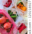 Farm market vegetables and fruits. Fresh natural cucumbers, tomatoes, persimmon and red peppers in plastic bags on the kitchen table. 120218927