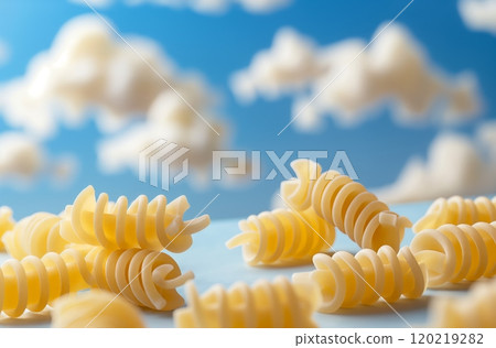 Fusilli pasta lying on a table with clouds in the background 120219282