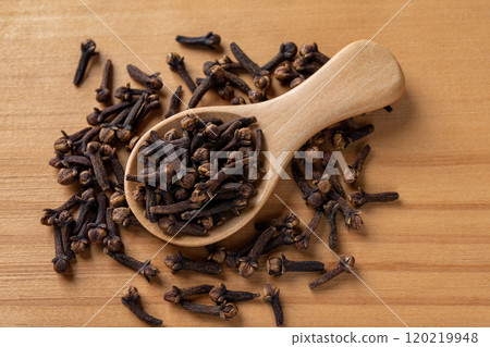 Whole cloves spice in a spoon over wooden background. 120219948
