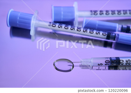 Injection syringes on a medical tray in bright violet color. Injection syringes on a medical tray in bright violet color. 120220096