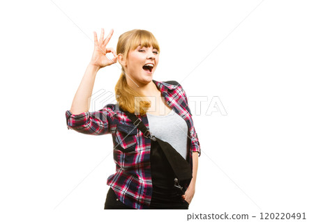 Woman in dungarees showing a ok gesture Woman in dungarees showing a ok gesture 120220491