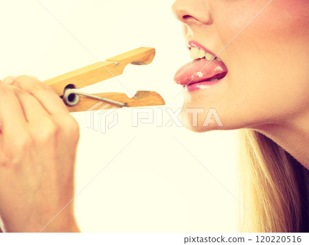 Blonde woman having tongue in clothespin 120220516