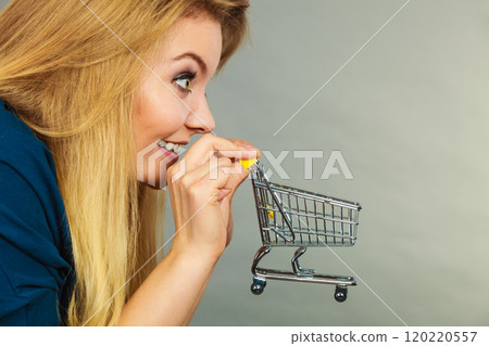 Happy woman holding small tiny shopping cart 120220557