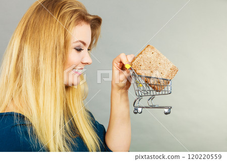 Woman holding shopping cart with bread 120220559