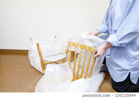 一位女士打開了一張她在網路上購買的椅子 120220844