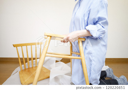 A woman unpacking a chair purchased online A woman unpacking a chair purchased online 120220851