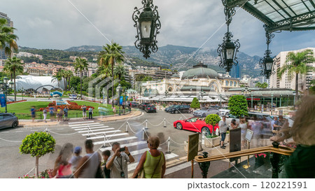 Tourists make pictures near expensive cars and famous Casino building timelapse in Monte Carlo in Monaco. 120221591
