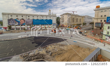 Asphalt paver, roller and truck on the road repair site during asphalting timelapse. Road construction equipment. Asphalt paver, roller and truck on the road repair site during asphalting timelapse. Road construction equipment. 120221855