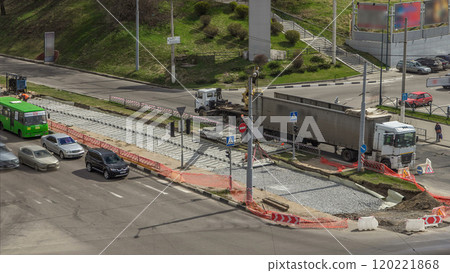 Loader crane for loading and unloading sleepers from truck which stands on a road construction site aerial timelapse 120221868