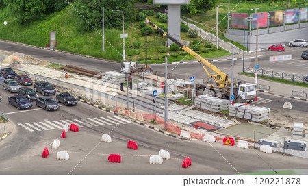 Loader crane for loading and unloading concrete plates from truck which stands on a road construction site aerial timelapse Loader crane for loading and unloading concrete plates from truck which stands on a road construction site aerial timelapse 120221878