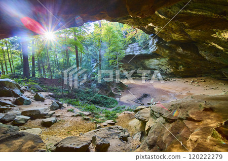Cave to Forest View with Sunlit Greenery and Figures in Distance 120222279