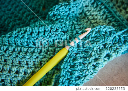 Vibrant Blue Yarn and Green Crochet Hook in Motion Close-Up Vibrant Blue Yarn and Green Crochet Hook in Motion Close-Up 120222353