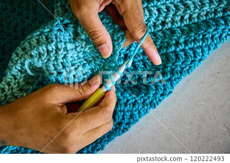 Hands Crafting Crochet with Blue Yarn Closeup View 120222493