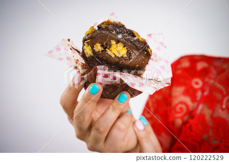 Woman holding sweet delicious chocolate cupcake Woman holding sweet delicious chocolate cupcake 120222529