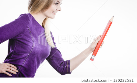 Smiling woman holds big pencil in hand Smiling woman holds big pencil in hand 120222581