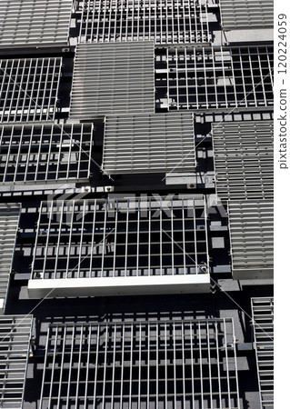 The wall of a modern building with randomly placed metal louvers of various designs and sizes 120224059