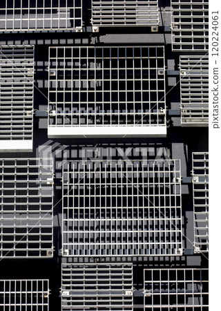 The wall of a modern building with randomly placed metal louvers of various designs and sizes 120224061