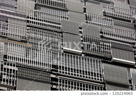 The wall of a modern building with randomly placed metal louvers of various designs and sizes The wall of a modern building with randomly placed metal louvers of various designs and sizes 120224063