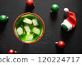 Xmas Grinch Punch in glass decorated sugar rim on black table make of cool lime sherbet. Tasty drink for Christmas holiday. Rim your festive beverages in red sugar. Close up. 120224717
