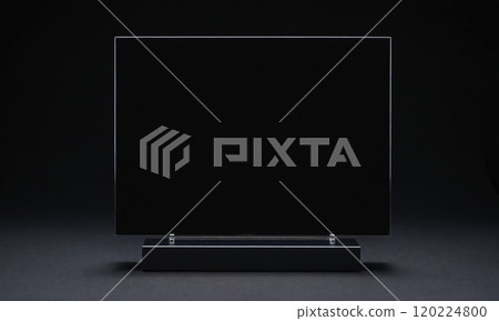 A black television sits on a black stand against a black backdrop 120224800