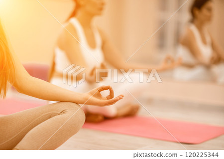 Two beautiful women cook doing yoga, sports together in the gym. Dressed in pink suits. The concept of grace and beauty of the body. Two beautiful women cook doing yoga, sports together in the gym. Dressed in pink suits. The concept of grace and beauty of the body. 120225344