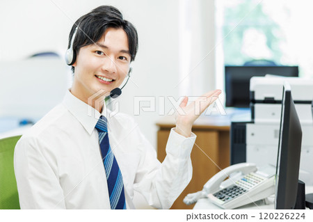 A businessman who wears a headset and answers the phone 120226224