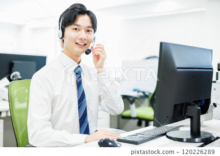 A businessman who wears a headset and answers the phone 120226289