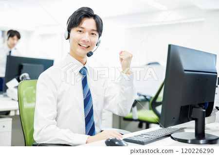 A businessman who wears a headset and answers the phone 120226290