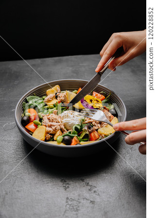 Healthy tuna salad with poached egg, fresh veggies, and edible flower, colorful and nutritious meal 120228852