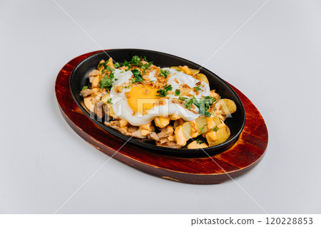 Loaded breakfast skillet with crispy potatoes, creamy sauce, and a fried egg on top Loaded breakfast skillet with crispy potatoes, creamy sauce, and a fried egg on top 120228853
