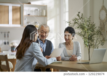 asian sales woman selling product to old couple 120229874