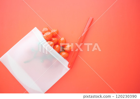 Fresh Cherry Tomatoes Displayed in a Transparent Bag Sitting Next to a Straw on a Vibrant Background Fresh Cherry Tomatoes Displayed in a Transparent Bag Sitting Next to a Straw on a Vibrant Background 120230390