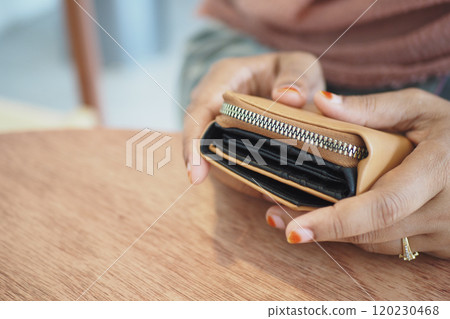 A stylish and fashionable wallet rests elegantly on a beautifully polished wooden table surface A stylish and fashionable wallet rests elegantly on a beautifully polished wooden table surface 120230468