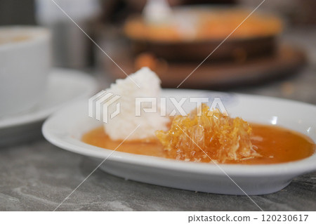 butter cream and honey in a bowl on table . butter cream and honey in a bowl on table . 120230617