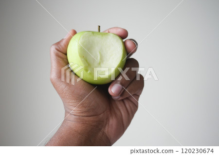 A Fresh Green Apple Held Gracefully in Hand, Signifying a Healthy and Wholesome Snack Choice A Fresh Green Apple Held Gracefully in Hand, Signifying a Healthy and Wholesome Snack Choice 120230674
