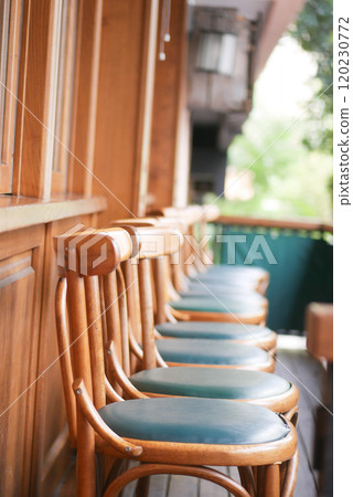 Beautiful and Elegant Wooden Bar Stools Featuring Green Cushions on a Cozy Balcony Setting 120230772